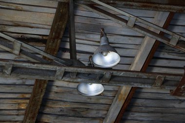 Eski, çürümüş ahşap tavan, büyük demir lambalar, paslı çelik yapılar, örümcek ağları ve küf.