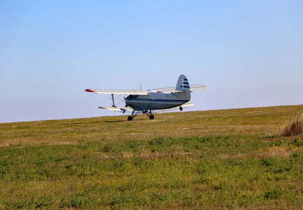 一种小型双翼飞机 一种农业玉米飞机 装有一种特殊的化肥和杀虫剂扩散器 它加速了飞行速度 并在秋天的田野上空起飞 — 图库照片