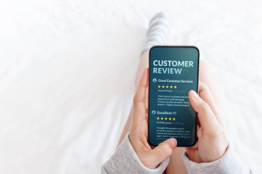 Müşteri deneyimi kavramı. Önce satın alma ürünleri ve Hizmetleri, daha olumlu geribildirim üstünde hareket eden perde Smartphone üzerinden okuma Online İnceleme yatağa yatan kadın