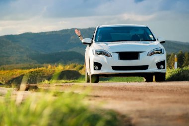 Seyahat kavramı. Mutlu Traveler kadın arabasını yolda sürüş. Arka plan olarak el ve gülen, güzel ağaçlar ve dağlar tepeler yükseltmek