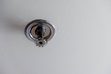 Sprinkler, yangın söndürücüyü binanın içinde beyaz tavanda yangın