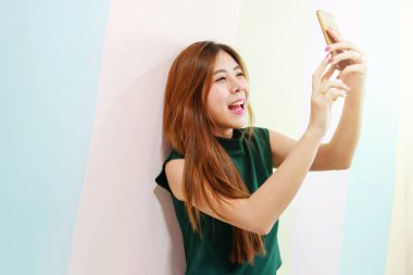 Selfie ya da Video seslenmek biriyle çekmek için akıllı telefon kullanırken portre genç gülümseyen kadın. Yaşam tarzı Modern kadın