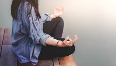 Genç kadın uygulamaları Yoga açık. Lotus pozisyonda oturuyor. Unplugged hayat ve ruh sağlığı kavramı. Sukhasana duruş ve meditasyon
