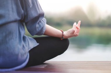 Genç kadın uygulamaları Yoga açık. Lotus pozisyonda oturuyor. Unplugged hayat ve ruh sağlığı kavramı. Sukhasana duruş ve meditasyon