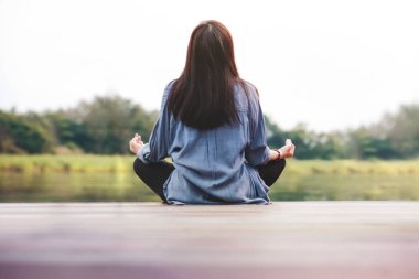 Genç kadın uygulamaları Yoga açık. Lotus pozisyonu oturuşta