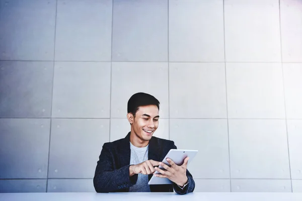 Feliz joven empresario asiático trabajando en la tableta digital. Sonriendo. — Foto de Stock