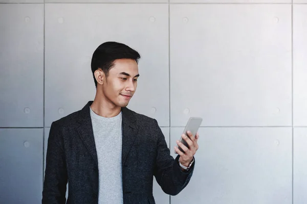 Ritratto di giovane uomo d'affari felice utilizzando Smartphone. In piedi b — Foto Stock