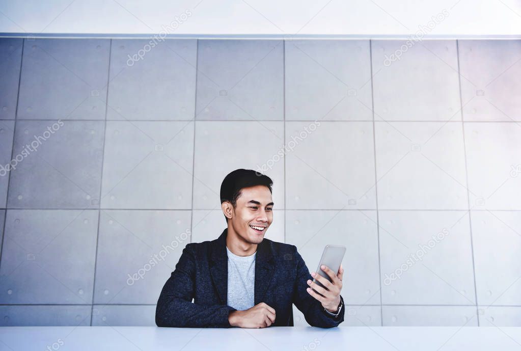 Happy Young Asian Businessman Working on Smartphone. Smiling and