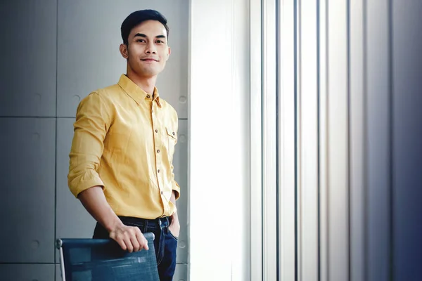 Ritratto di giovane imprenditore in piedi vicino alla finestra in ufficio . — Foto Stock