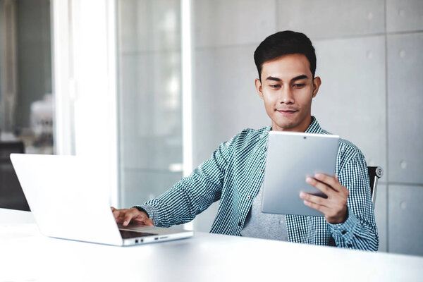 Young Businessman Working on Computer Laptop in Office. Smiling 