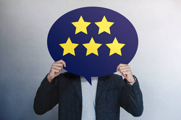 Концепция работы с клиентами. Счастливый клиент показывает рейтинг пяти звезд за положительный отзыв о карточке с пузырьком речи
.