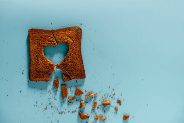 Mutsuz İlişki kavramı. Kırık Kalp şeklinde Yanmış Dilimlenmiş Tost Ekmek Düz Lay. En İyi Görüntü