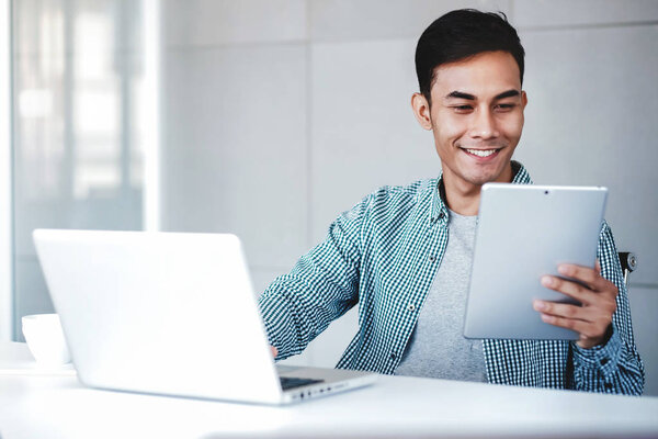 Happy Young Businessman Working on Computer Laptop and Digital T