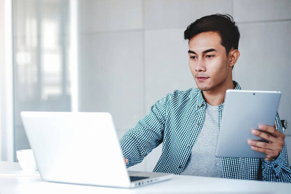 Happy Young Businessman Working on Computer Laptop and Digital T