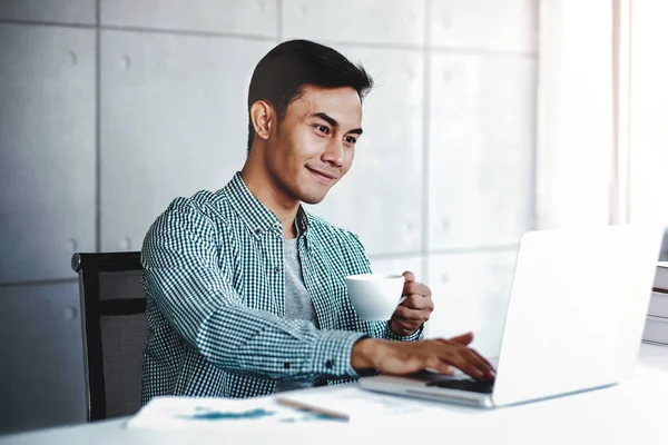 Ευτυχισμένος νέος επιχειρηματίας εργασίας στον υπολογιστή laptop, ενώ ο πότης — Φωτογραφία Αρχείου