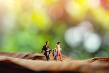 Sevgi ve Mutlu Aile. İş, Yaşam, Denge Kavramı. Baba, Anne ve Oğulun El Ele Tutuşup Parkta Kuru Yaprakta Yürümesinin Minyatürü