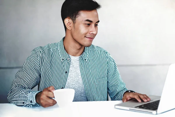 Szczęśliwy młody biznesmen pracujący na laptopie komputerowym w biurze. Sm — Zdjęcie stockowe