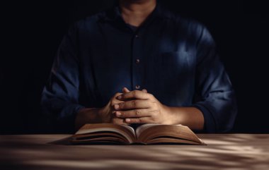 Maneviyat ve Din Konsepti, Kilise 'de ya da Evdeki Kutsal İncil' de Dua Etmek İçin Masada Oturan Kişi. Hristiyan Halkı İçin İnanç ve İnanç