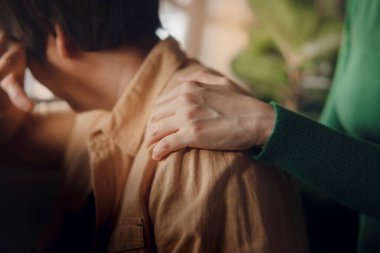 Travma sonrası stres bozukluğu, cesaret verici bir kavram. Bunalımlı Bir Kişiye Yardım Etmek İçin Rahat Bir El ile Dokunmak. Arkadan sarılıyor.