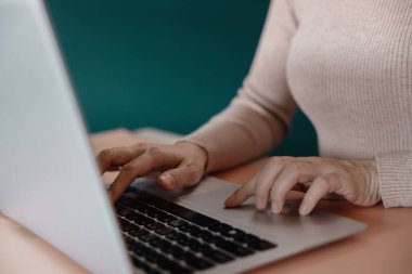 Bilgisayarda çalışan genç bir kadın. Yakın çekim ve Kırpılmış Resim