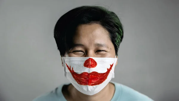 コヴィッド 19の状況コンセプトでハロウィン 外科用マスクを着用して幸せな人 仮面の上に描かれた赤い笑顔の口紅 — ストック写真