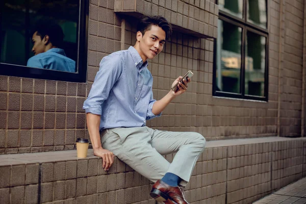 Sonriente Joven Empresario Asiático Usando Teléfono Móvil Ciudad Mirando Cámara — Foto de Stock