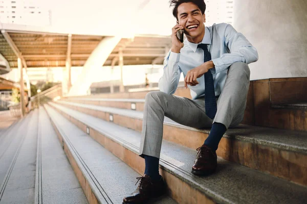 Sonriente Joven Empresario Asiático Usando Teléfono Móvil Ciudad Sentado Escalera — Foto de Stock