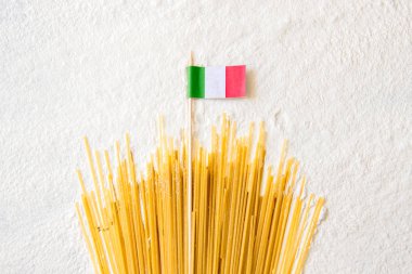 Pişmiş makarna spagettisi makarna ve İtalyan bayrağı üzerinde beyaz arka plan. Yükselen güneş ışınları şeklinde Macaroni