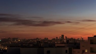 Şehir şehir Sunset Time Lapse Gündüz Gece 4k. Gün batımında şehir silüeti zaman aşımı. Modern şehrin muhteşem panoramik manzarası. Yeni yerleşim alanlarında vinçli şantiye