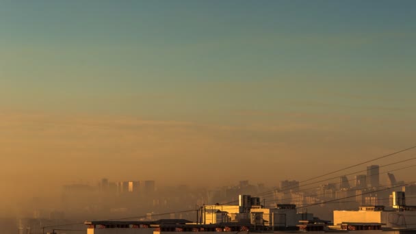 霧の黄色の光の朝に都市の近代的なスカイラインのタイムラプス。屋上からの航空写真。換気、ワイヤー、階段 — ストック動画