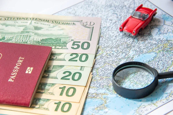 Vado a viaggiare. Passaporto, lente di ingrandimento, macchina giocattolo rosso e denaro sulla mappa. Risparmiare denaro sui viaggi, pianificazione per il concetto di bilancio . — Foto Stock