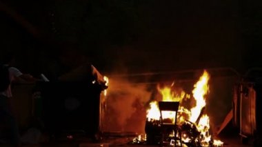 Yanan çöp konteyneri ve eski ahşap sandalye