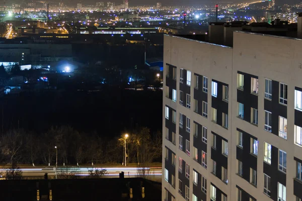 Hochhaus modernes Gebäude im abendlichen Fensterlicht. Lässiges urbanes Stadtleben. Verkehr auf der Straße. — Stockfoto