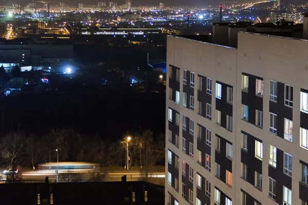 Hochhaus modernes Gebäude im abendlichen Fensterlicht. Lässiges urbanes Stadtleben. Verkehr auf der Straße vom Turmdach — Stockfoto