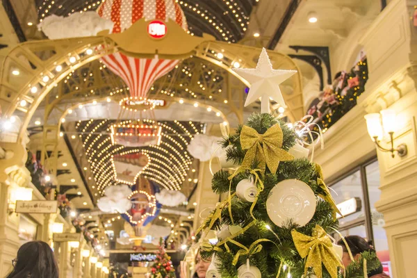Moskau, russland - 06. Dezember 2017: Dekoration der Kaugummi-Mall während der Winterferien. Teetassen und Untertassen aus weißem Porzellan mit goldenen Bändern auf grüner Tanne — Stockfoto