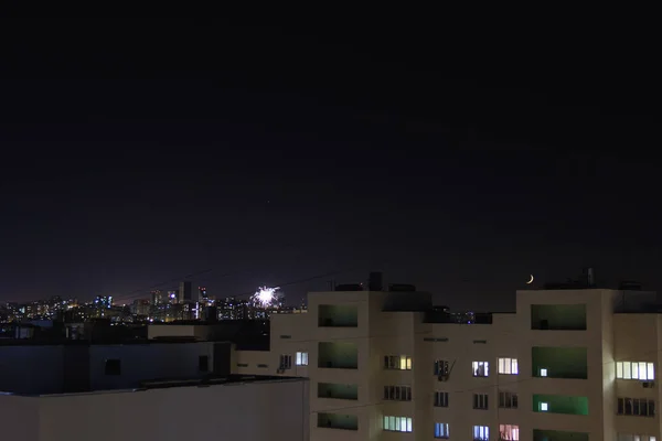 夜城星星和新月在天空中移动。住宅公寓的窗户亮着，关了。城市天际线与高层建筑 — 图库照片