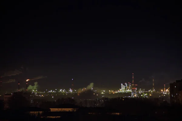 Zone industrielle nocturne de la ville.Fumée provenant des tuyaux de fabrication et de combustion de gaz. L'aeria résidentielle abrite des lumières scintillantes. Changement climatique — Photo