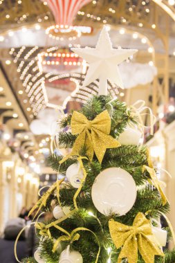 Moskova, Rusya - 06 Aralık 2017:Kış tatillerinde Sakız alışveriş merkezi süslemeleri. Yeşil köknar üzerinde altın kurdeleler ile beyaz porselen çay bardak ve tabaklar