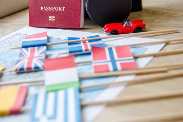 Vlaggen op reizen kaart, paspoort, retro camera, rode speelgoed auto. planning concept reisbestemming — Stockfoto