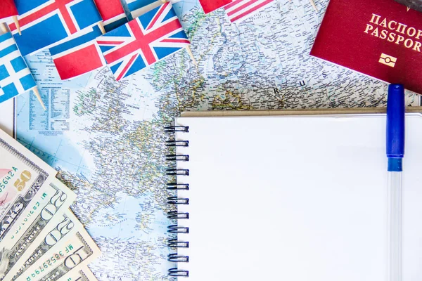 Reisvoorbereiding: geld, paspoort, routekaart, open notitieboekje, nationale vlaggen op houten tafel. Vakantie plan — Stockfoto