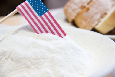 Bir tabakta Amerikan bayrağı ve unun yakın çekim. Arka planda ekmek dilimleri
