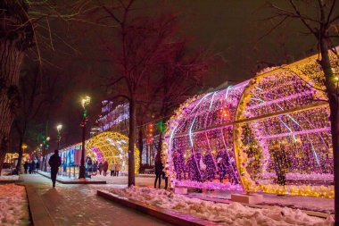 Moskova, Rusya - 21 Aralık 2017: İnsanlar ve turistler Yeni Yıl ve Noel tatilleri için dekore edilmiş Tverskaya caddesi boyunca yürüyorlar