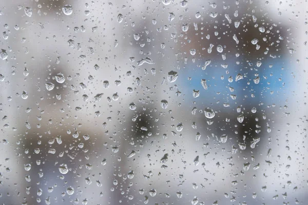 Stagione delle piogge, gocce di pioggia sul vetro della finestra sta visualizzando lo skyline della città in una giornata di tempo buio. Fondo astratto pioggia — Foto Stock