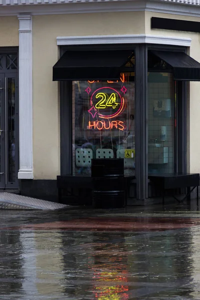 Откройте 24 часа в сутки неоновую вывеску на витрине ресторана с надписью. Летний дождик — стоковое фото