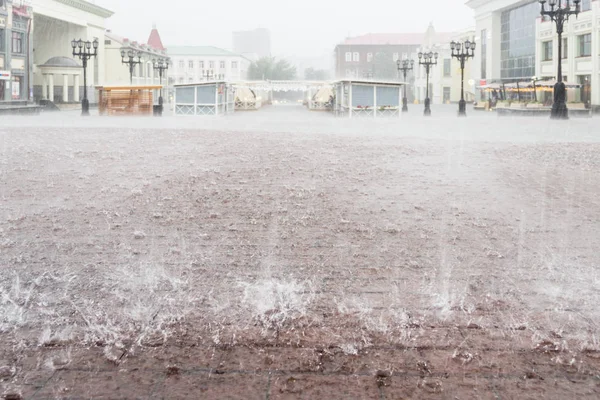 城里下着大雨。城市广场。用水下的矩形瓷砖封闭人行道 — 图库照片