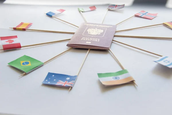 Закордонний паспорт Російської Федерації та прапори різних країн навколо: Індія, Бразилія, Великобританія, Італія, Норвегія, Австралія — стокове фото