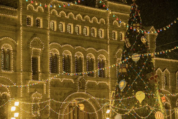 Kerstversiering op een gevel, grote kerstboom met ballen en presenteert, stad nachtverlichting. Nieuwjaar in Moskou, Rusland. Zware sneeuwval — Stockfoto