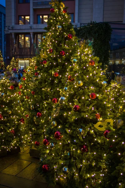 Christbaumhintergrund und Weihnachtsschmuck. bunte Kugeln und Girlanden auf grüner Tanne — Stockfoto