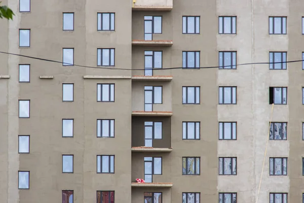 Cantiere con edificio grigio incompiuto in giorno d'estate . — Foto Stock