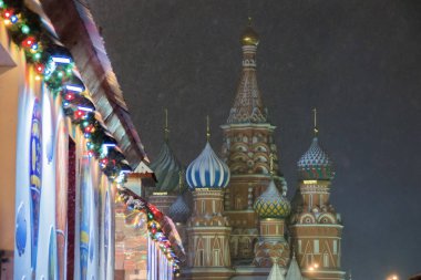 Yeni yıl ve tatil için süslemeler. Kar yağışı sırasında çok renkli çelenk, Moskova'da Kırmızı meydanda St Basil Katedrali